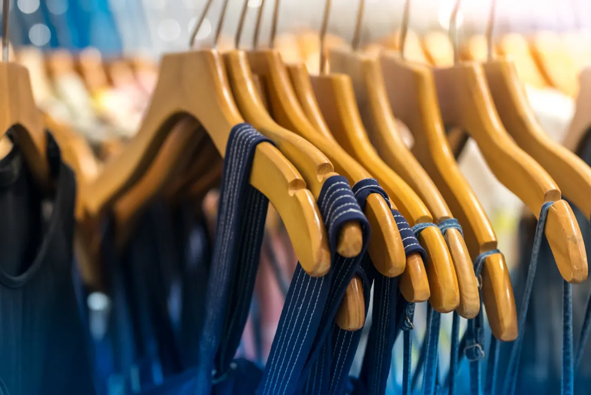 Prendas colgadas en perchas de madera
